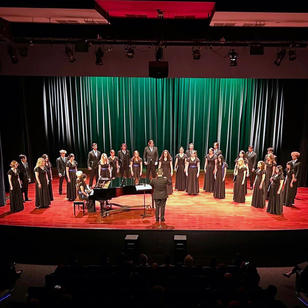 A large choir performs on stage